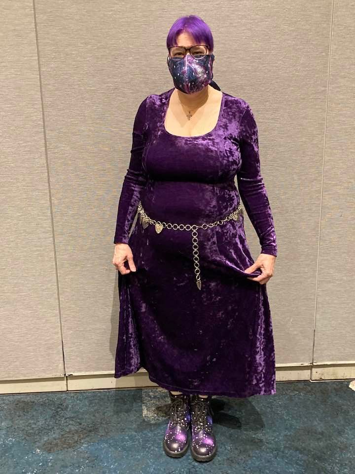 Dr Karen in purple crushed velvet gown, purple hair, galaxy print facemask, galaxy print boots.